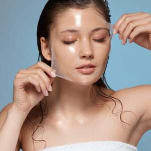 pretty female taking off purifying mask with her eyes closed, girl with wet hair removing moisturizer, fresh and clean skin